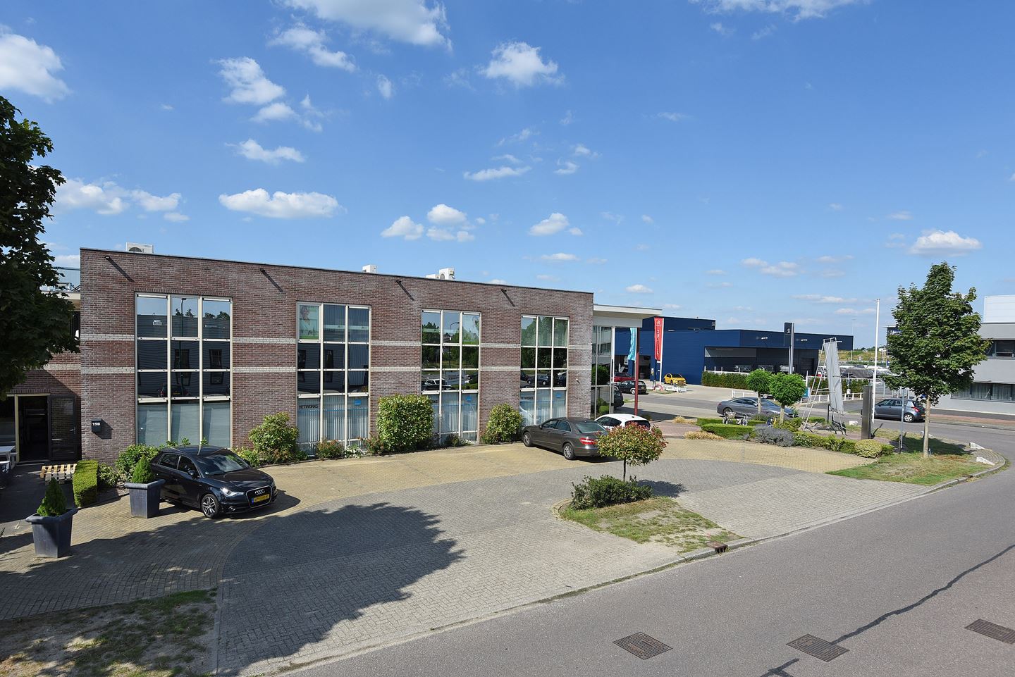 Bedrijfspand Veenendaal aan de Newtonstraat met beschikbare kantoorruimtes en parkeerplaatsen, gelegen op bedrijventerrein De Compagnie.