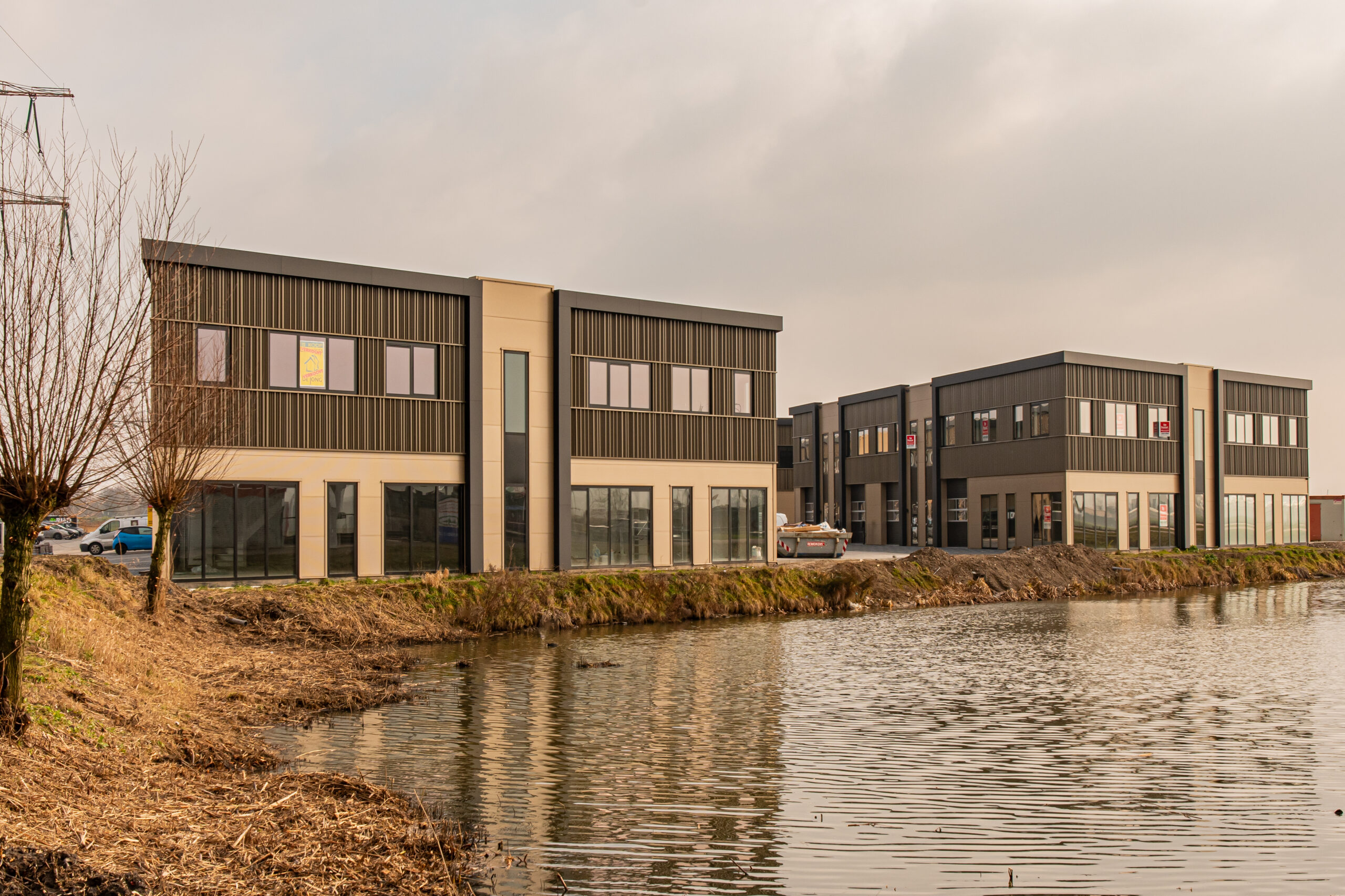Afbeelding van een bedrijfspand in Heinenoord. De bedrijfspanden bevinden zich naast water en lucht is dreigend.